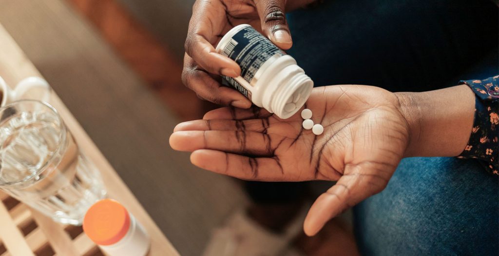 Imagem de uma mão segurando várias pÃlulas de remédio, simbolizando cuidado com a saúde e tratamento médico. Compreenda a importância da medicação e gestão da saúde para um estilo de vida equilibrado.